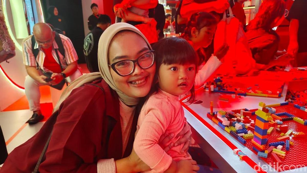 Fitri (32) bersama Zoya (2) saat mencoba bermain Lego di Morinaga Door Of Future 'Dunia Generasi Platinum Advance Intelligence Lab. (Foto: Aldrian/detikHealth)
