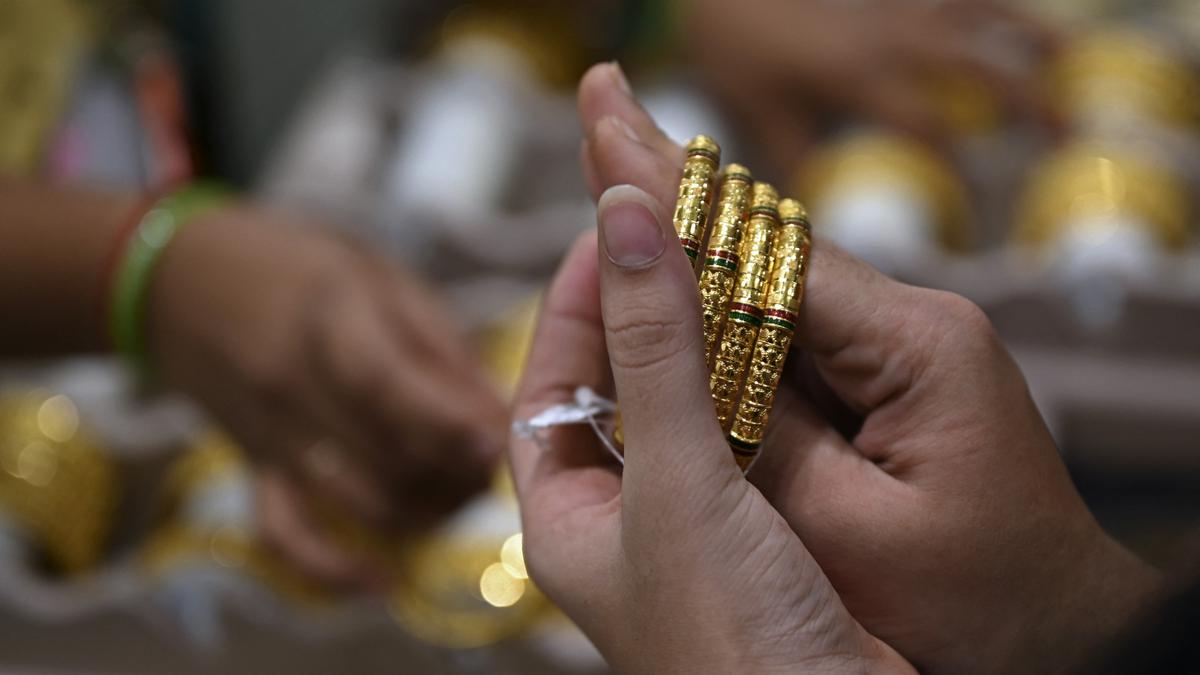 Seorang pelanggan mencoba gelang emas selama festival Hindu 'Akshaya Tritiya', hari keberuntungan dalam kalender Hindu untuk membeli barang-barang berharga, di ruang pamer perhiasan di Chennai, India. (Arun SANKAR / AFP)