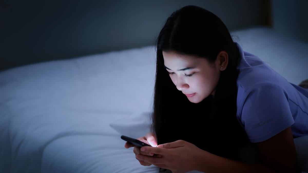 Foto: Ilustrasi bangun tidur melihat ponsel (Getty Images/iStockphoto/Pongchart)