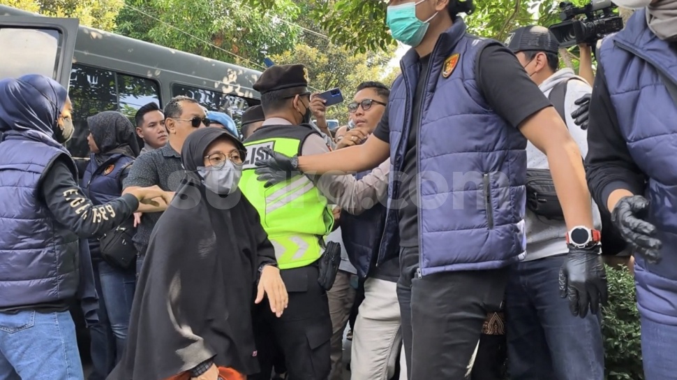 Ketua Yayasan Daycare Little Aresha, DK (51, perempuan berhijab hitam pakai masker) saat tiba di lokasi rekonstruksi, Selasa (9/6/2026). (Suara.com/Hiskia)